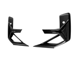 Two sleek, carbon fiber car parts with angular designs face each other on a white background, featuring mounting holes and overlapping geometric lines for aerodynamics.