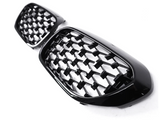 A pair of black, honeycomb-patterned car grille inserts are positioned on a plain white background, showcasing their glossy finish and intricate design.