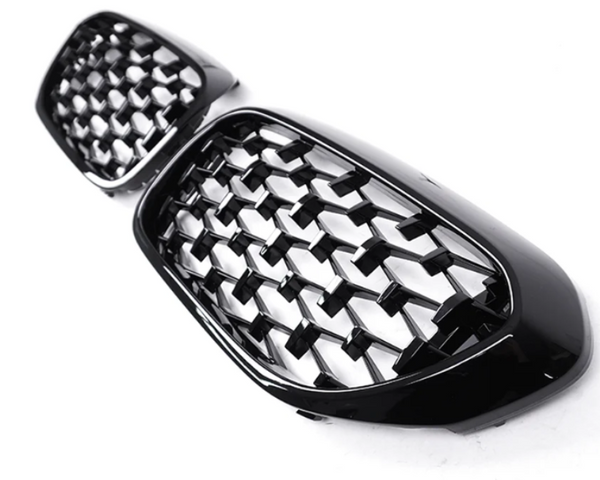 A pair of black, honeycomb-patterned car grille inserts are positioned on a plain white background, showcasing their glossy finish and intricate design.