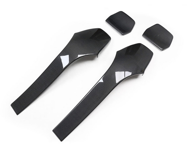 Two sleek, black carbon fiber car trim pieces are positioned on a plain white background. Above them, two smaller matching components are aligned, showcasing an elegant design.