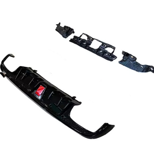 Car bumper kit featuring a black front bumper and additional panel pieces, arranged on a plain white background. A small, red label is visible on the bumper.