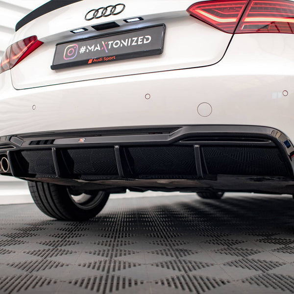 A white car's rear view features dual exhausts and a black diffuser. It is parked on a textured floor. The license plate reads "#MAXTONIZED @Audi Sport" with Audi badge above.