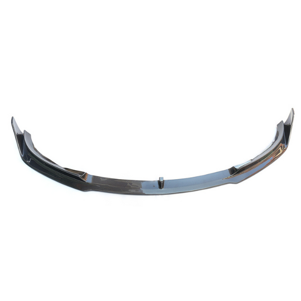 A black carbon fiber car front lip spoiler rests on a plain white background, showcasing its sleek, aerodynamic design with raised ends and slight curvature.