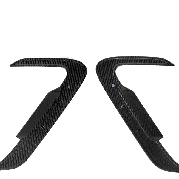 Two curved, black carbon fiber car parts with pointed ends face each other symmetrically on a plain white background, displaying polished surfaces and small holes near the center.