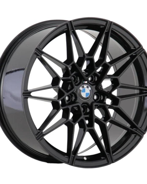 A black alloy wheel features a complex, geometric spoke design centered by a BMW logo, displayed against a plain white background.