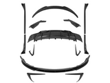 Carbon fiber car body kit parts, precisely arranged, suggesting assembly. Components include a diffuser, spoilers, side skirts, and splitters, placed on a plain white background.