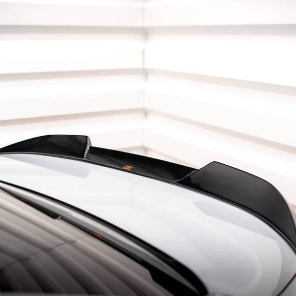 A car roof with a black spoiler sits stationary, surrounded by a white, segmented background, creating a modern, sleek atmosphere.