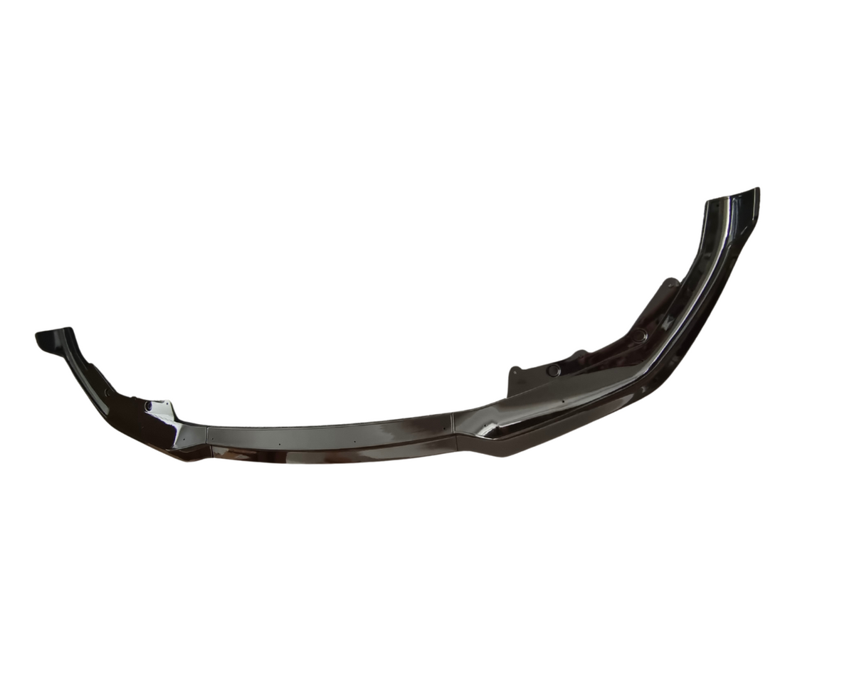 A glossy black car bumper lies horizontally in a featureless white background, showcasing a curved shape with mounting points and sleek edges.