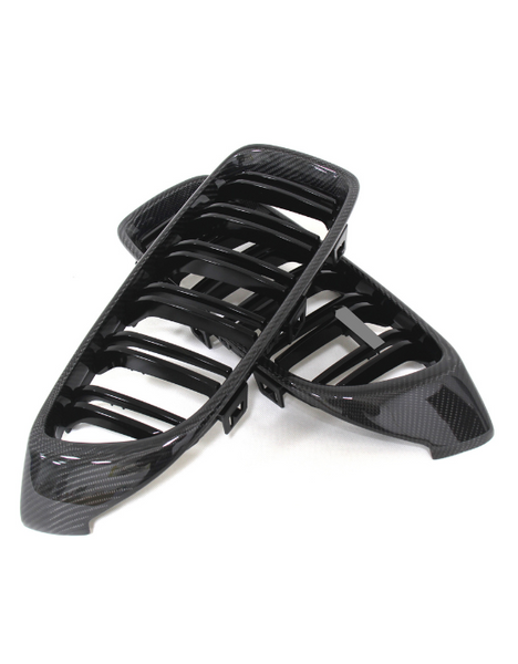 Two black car grilles with a glossy carbon fiber finish are stacked on a white background, showcasing a sleek, modern design with multiple horizontal slats.