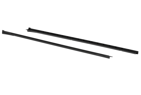 Two sleek black linear components lie parallel; segmented with grooves, likely parts for assembly or structural support, positioned on a plain white background.