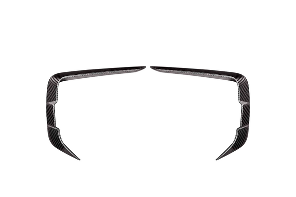 Two symmetrical, angled carbon fiber trim pieces facing each other on a plain white background, resembling elongated, curved brackets or stylized boomerangs.