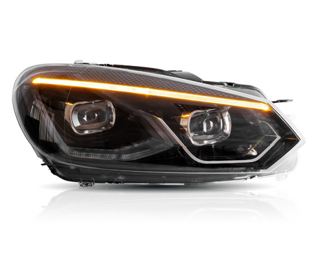A car headlight emits an orange light strip, featuring black housing and clear lenses, set against a plain white background.