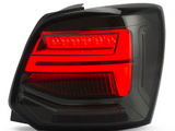 A modern, black car taillight illuminated with bright red LED strips, set against a plain white background, highlighting sleek design elements and reflective surfaces.