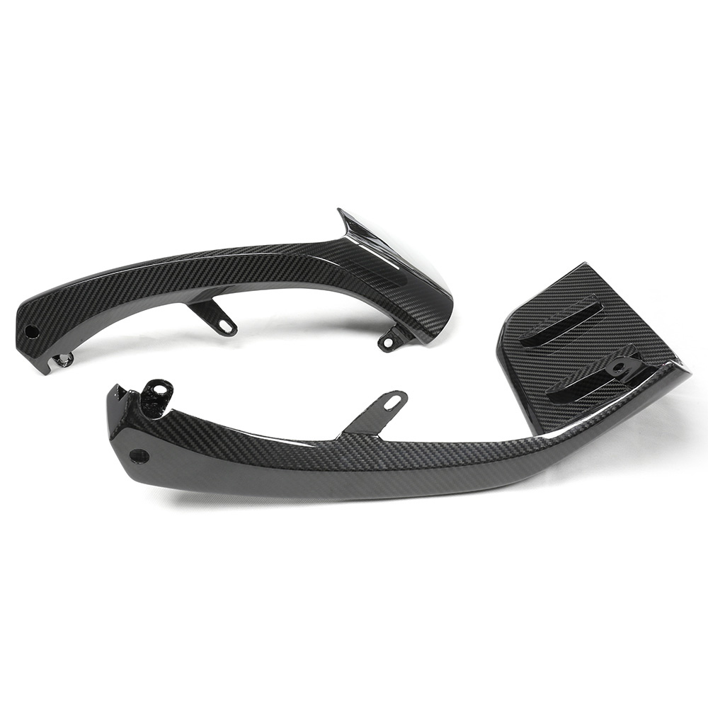 Two carbon fiber motorcycle components lie on a plain white background. The parts feature sleek curves and attachment points, suggesting they are used for structural or aerodynamic enhancements.