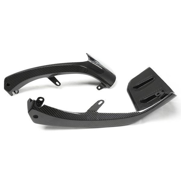 Two carbon fiber motorcycle components lie on a plain white background. The parts feature sleek curves and attachment points, suggesting they are used for structural or aerodynamic enhancements.