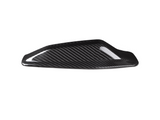 A sleek, black carbon fiber car mirror cap rests on a white background, showcasing its shiny, textured surface designed for aerodynamic enhancement.