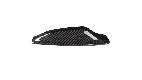 A sleek, black carbon fiber car mirror cap rests on a white background, showcasing its shiny, textured surface designed for aerodynamic enhancement.
