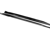 A pair of sleek black skis lies side by side, showcasing a glossy surface and streamlined design. The word 