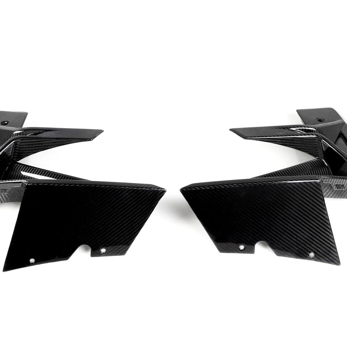 Two black carbon fiber car parts face each other, showcasing sleek, angular designs on a plain white background.
