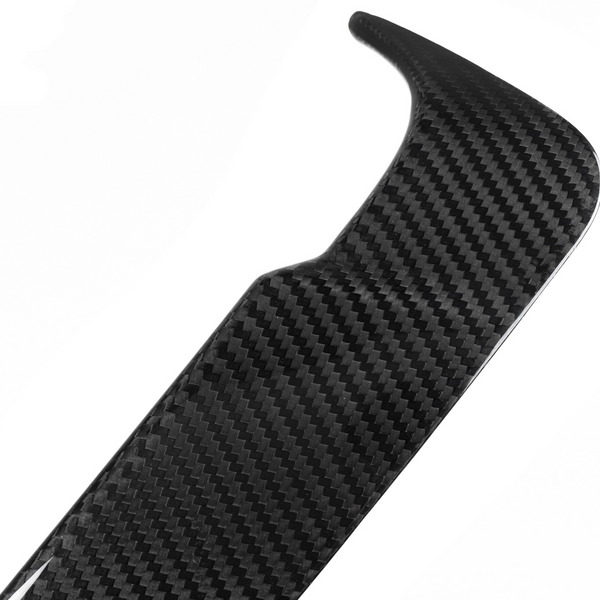 A black carbon fiber car spoiler with a textured pattern rests against a white background, showcasing its aerodynamic design.