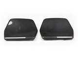 Two carbon fiber car mirror covers lie side by side on a plain white background, displaying a glossy texture and weave pattern, emphasizing their sleek, aerodynamic design.
