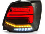 A car taillight assembly displays glowing red, amber, and white LED segments, set against a dark background, highlighting its sleek, modern design with reflective surfaces.