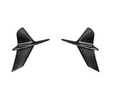 Two carbon fiber airplane-shaped figures pointing inward, each with angled wings and fins, set against a plain white background.