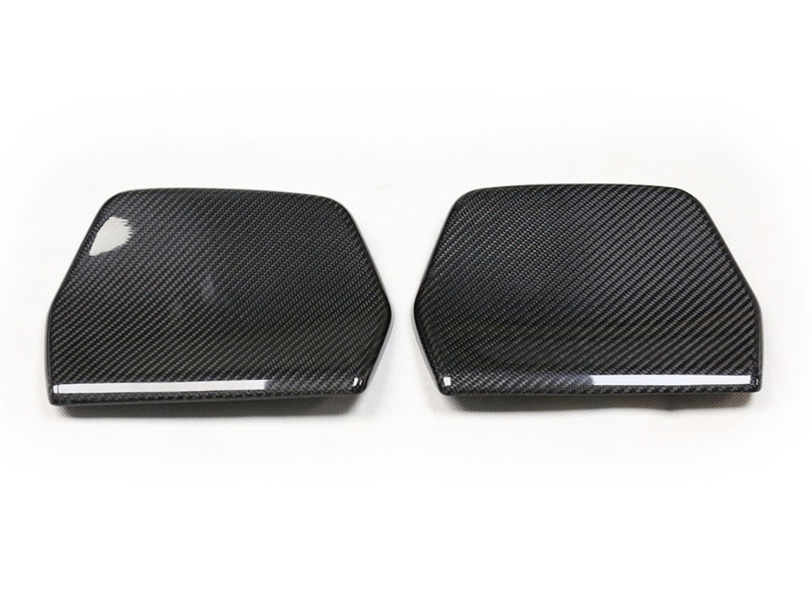 Two carbon fiber car mirror covers, arranged side by side on a plain white background, displaying a sleek, glossy surface with a distinctive woven pattern.