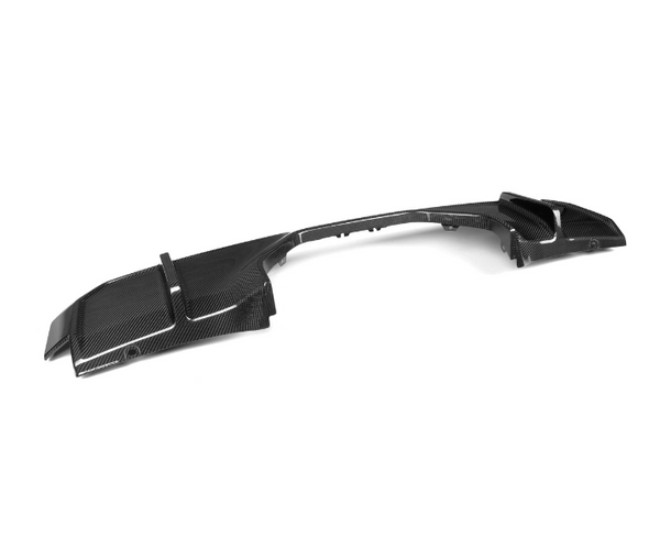 A carbon fiber car rear diffuser lies on a white surface, featuring aerodynamic grooves and ridges, designed for enhanced vehicle performance and aesthetics.