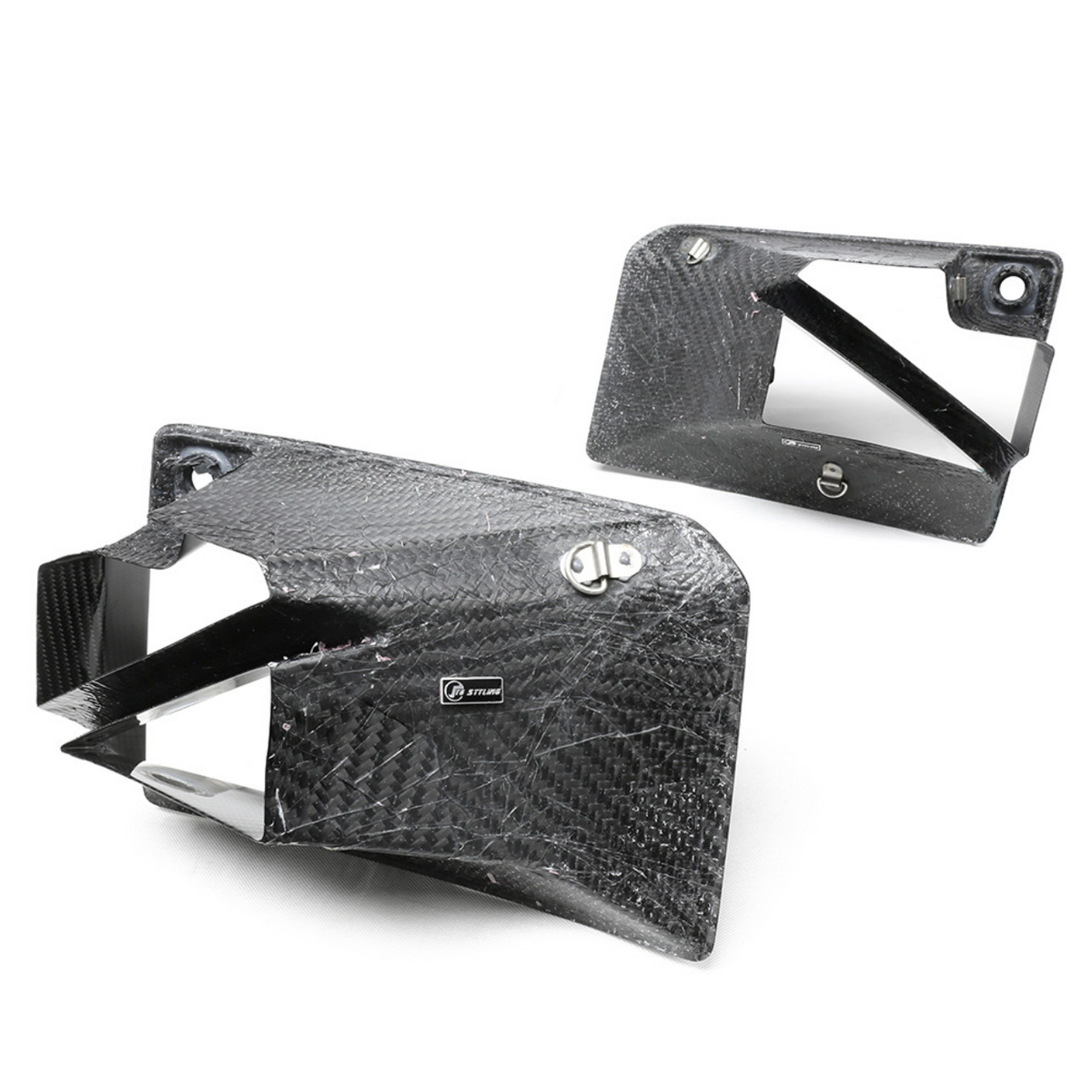 Carbon fiber ducts with a textured pattern are positioned against a plain white background. One duct displays a "STILER" label, suggesting a performance automotive application.