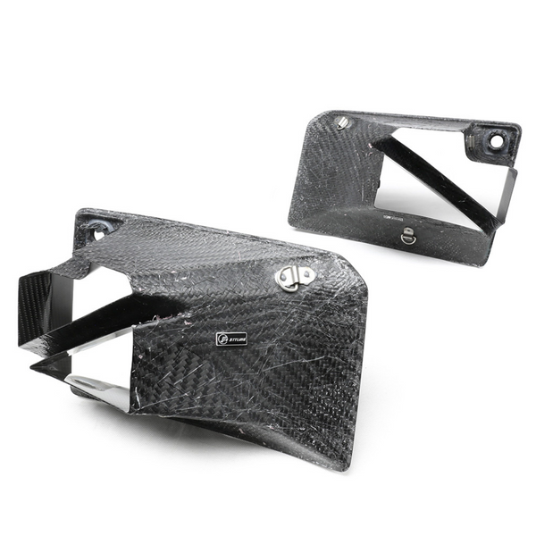 Carbon fiber ducts with a textured pattern are positioned against a plain white background. One duct displays a "STILER" label, suggesting a performance automotive application.