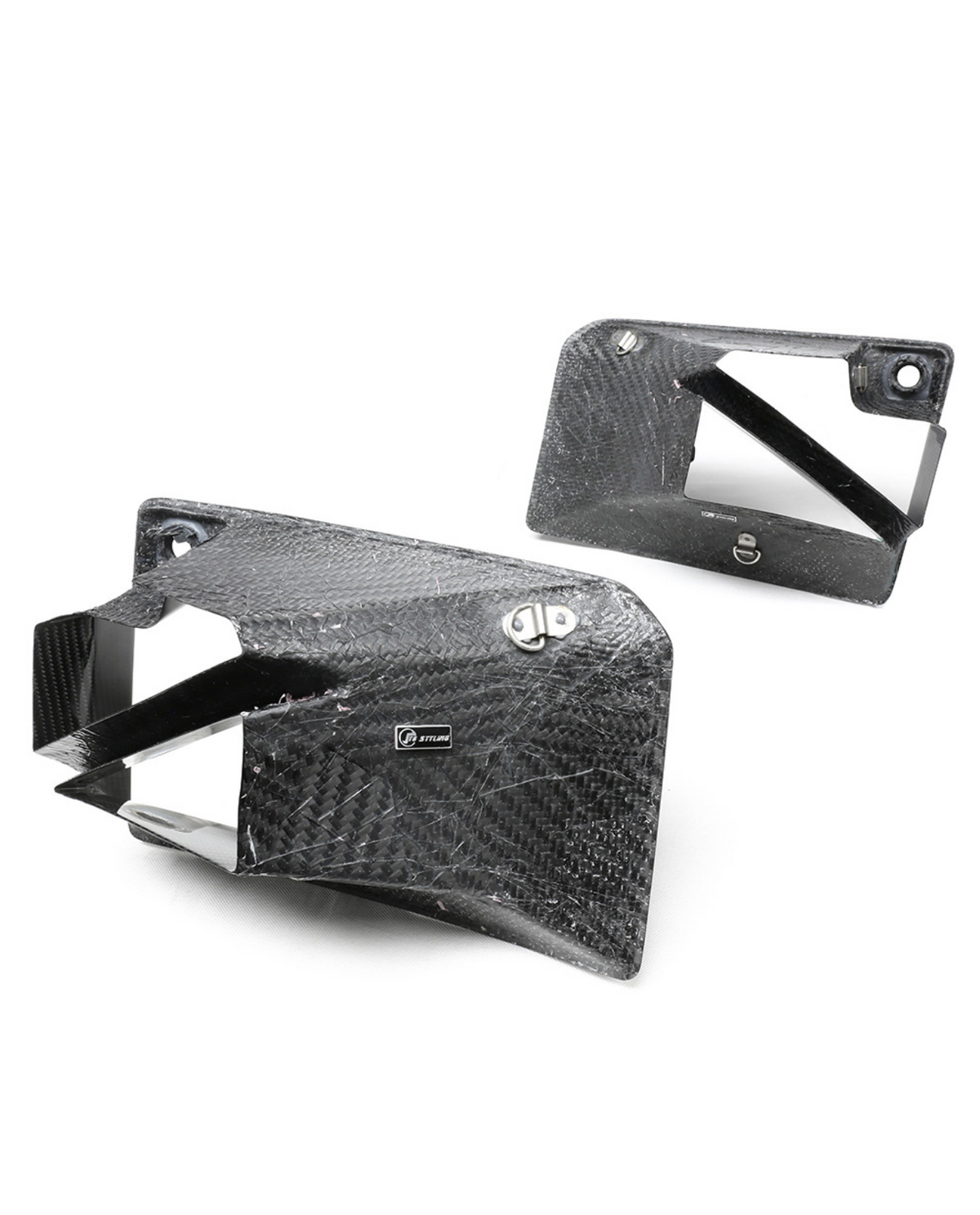 Carbon fiber ducts with a textured pattern are positioned against a plain white background. One duct displays a "STILER" label, suggesting a performance automotive application.