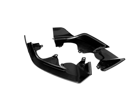 Carbon fiber automotive parts are arranged on a white background, displaying their shiny, textured surface and intricate design.