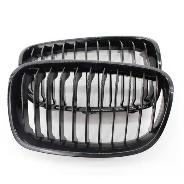 Two black kidney-shaped car grilles with vertical slats are positioned side by side, against a plain white background.