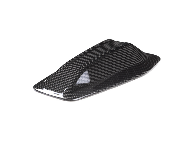 A carbon fiber shark fin antenna rests on a white background, showing a sleek, aerodynamic design with a glossy finish, typically used for vehicles.