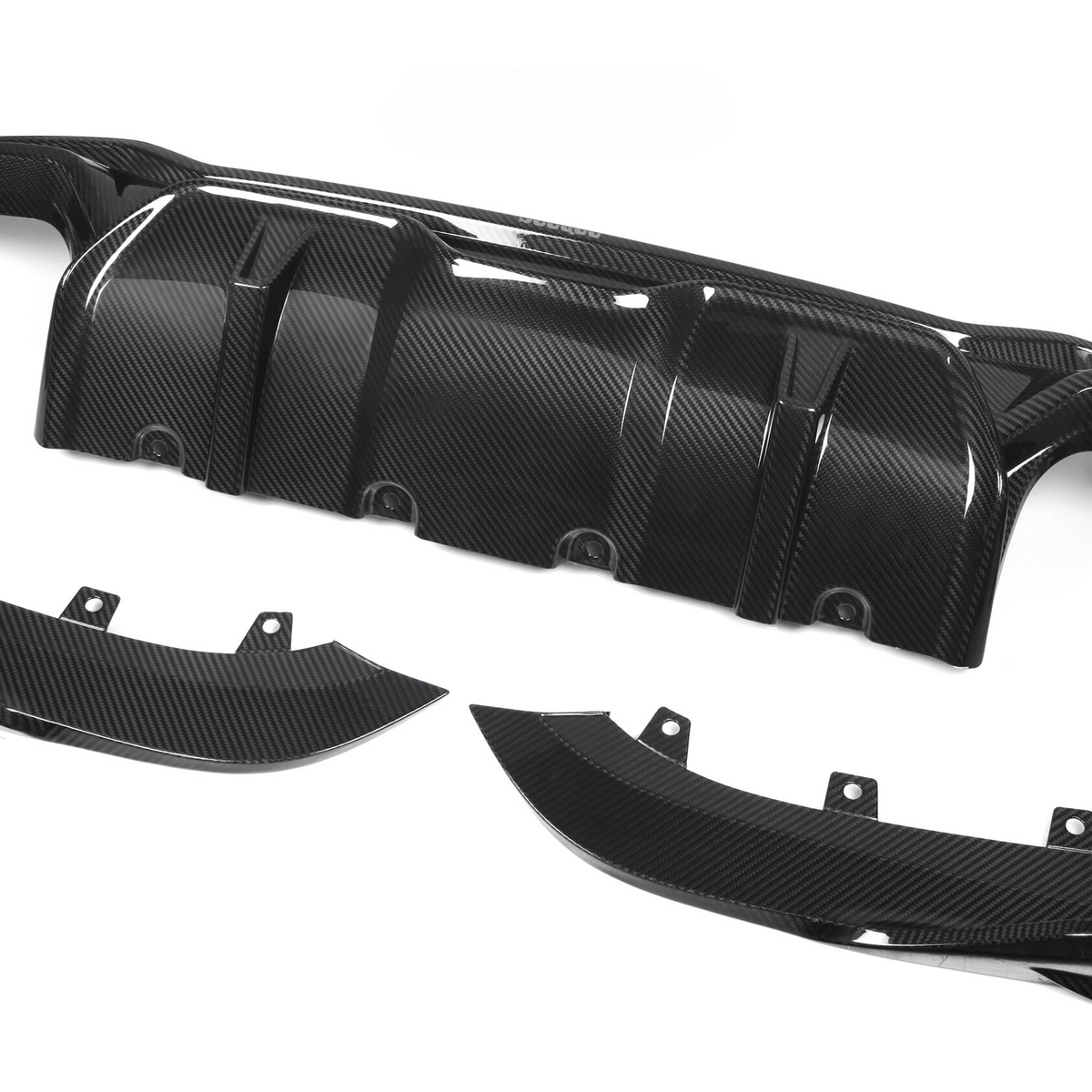 Carbon fiber car diffuser components lie on a white background. The main piece, with multiple ridges, is accompanied by two curved side parts, each featuring mounting brackets.