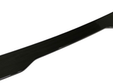 A glossy black car spoiler lies slightly curved against a white background, showing its aerodynamic form intended for enhanced vehicle performance.