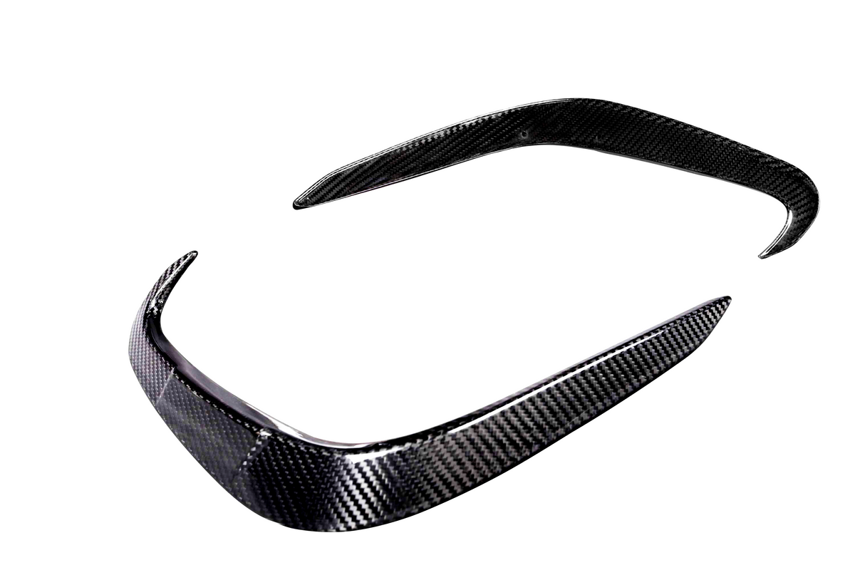 Carbon fiber car bumper parts, one with a curved edge and another elongated piece, are positioned against a plain white background, showcasing their sleek design and texture.