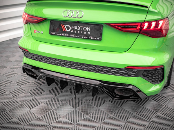 A green Audi RS 3 displays a Maxton Design license plate. The car is parked on a patterned floor indoors. The license plate reads: "MAXTON design www.AudiCityPlock.pl 661 636 900".