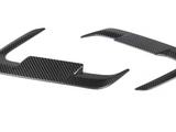 Carbon fiber steering wheel trim pieces, curved and glossy, rest on a plain white background.