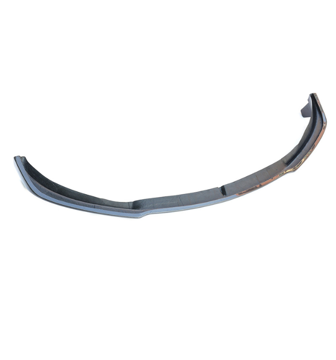 Curved car bumper, resting on a white background, designed for a sleek fit on the front of a vehicle, emphasizing aerodynamics and style.