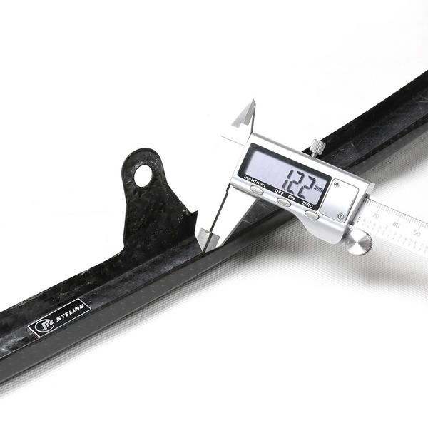 A digital caliper measures a black carbon fiber object labeled "STLINE," displaying "12.2 mm." The scene is well-lit on a white background, emphasizing precision measurement.