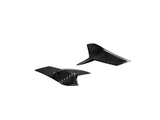 Two black carbon fiber fins rest on a white background, showcasing their textured, glossy surface.