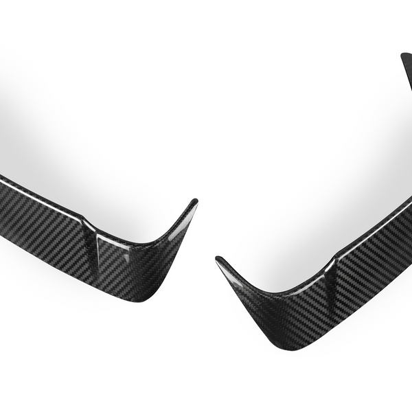 Two carbon fiber car bumper lips are positioned symmetrically. They have a glossy, textured surface and curved edges, set against a plain white background.