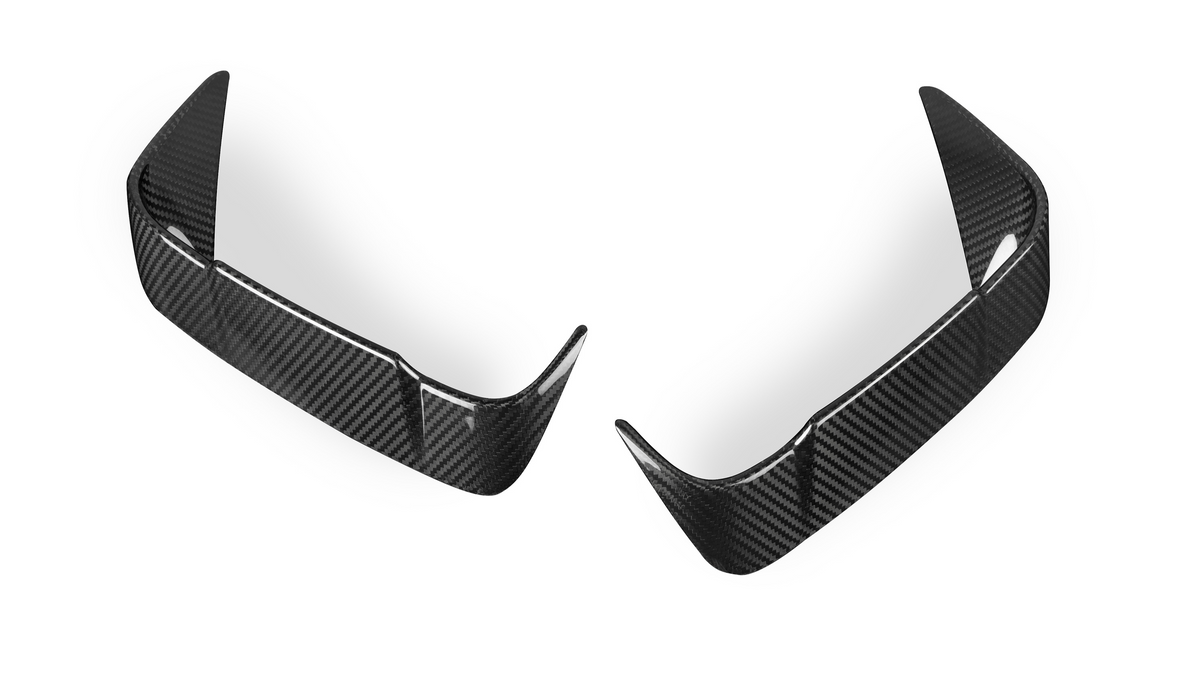 Two carbon fiber car bumper lips are positioned symmetrically. They have a glossy, textured surface and curved edges, set against a plain white background.