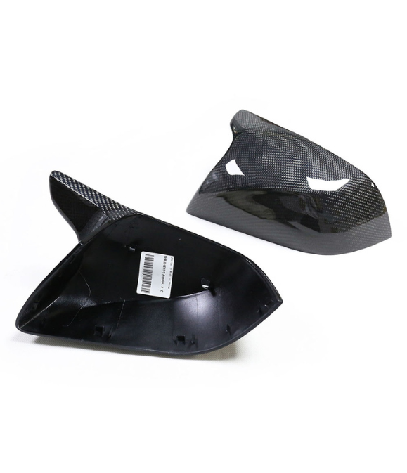 Two carbon fiber car mirror covers lie on a white background, one showing the inner side with a label reading "Cover Replacement - R," and the other displaying the textured exterior.