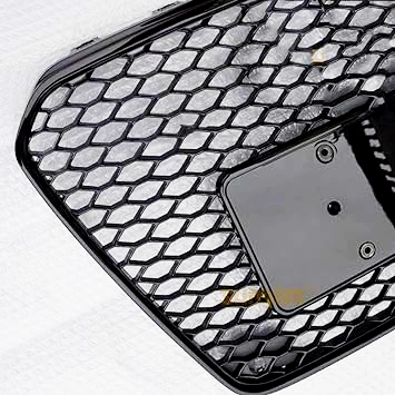 A black honeycomb grille with a smooth plate section sits against a textured white background. The grille features a grid pattern with a few mounting holes on the plate.