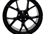 A black, multi-spoke alloy wheel is displayed against a white background, highlighting its sleek, modern design and glossy finish.