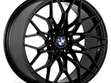 A black alloy wheel with a complex multi-spoke design featuring the BMW logo in the center. The wheel is displayed on a white background, highlighting its intricate structure.