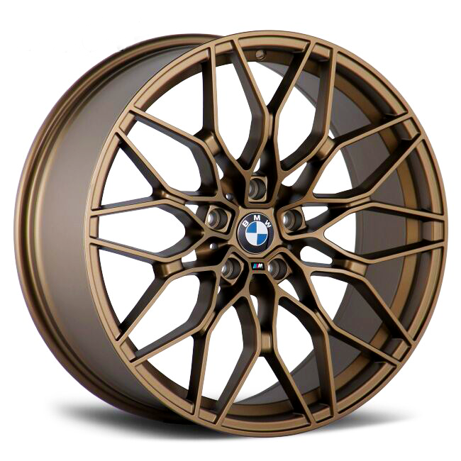 A bronze alloy wheel with intricate, multi-spoke design features a central emblem displaying "BMW." It rests on a white background, emphasizing its elegant and complex structure.